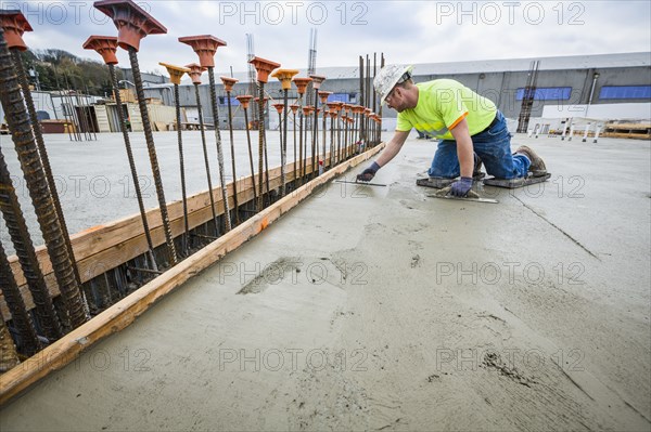 Worker finishing concrete at construction site
