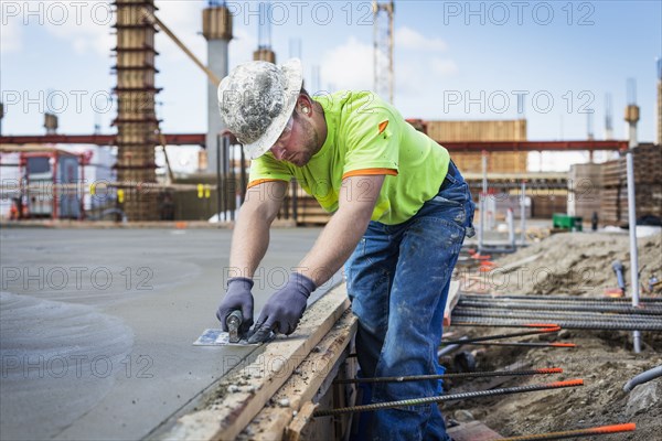 Construction worker finishing concrete at construction site