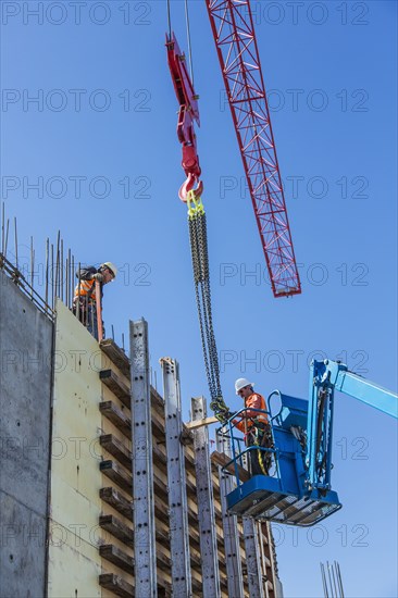 Workers on concrete wall form on construction site