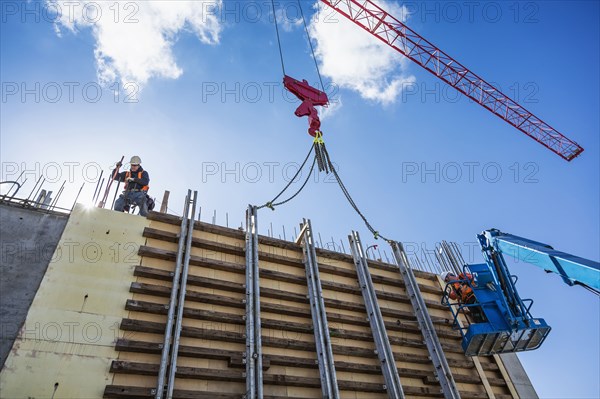 Workers on concrete wall form on construction site