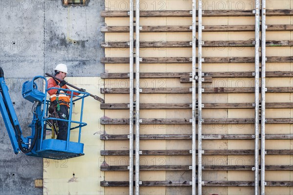 Caucasian worker on boom lift working on construction site