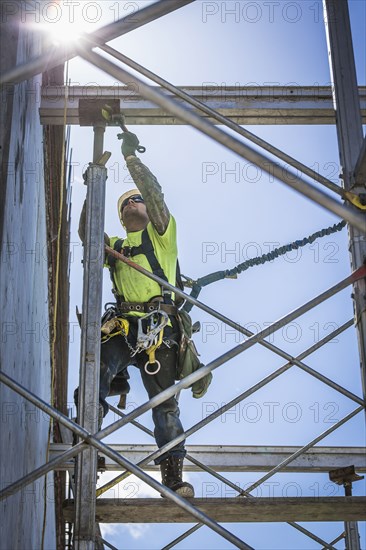 Caucasian worker on scaffolding on construction site