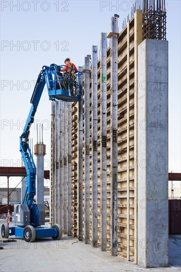 Caucasian worker on boom lift at construction site