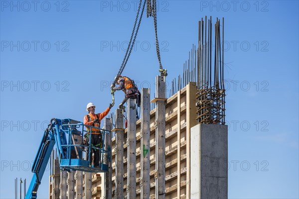 Workers on concrete wall form on construction site