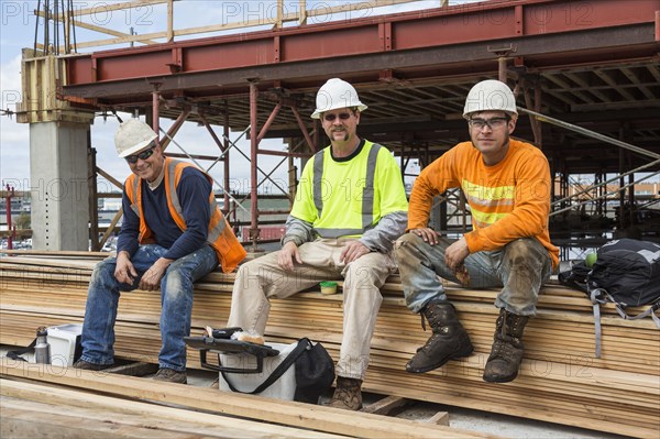 Caucasian workers smiling at construction site