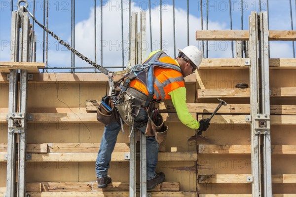 Caucasian worker hammering wood at construction site