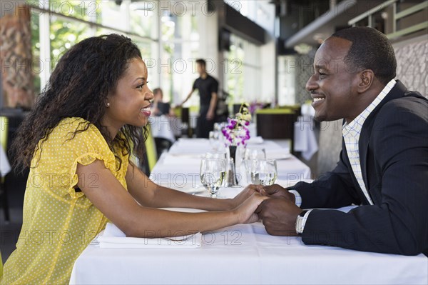 African American couple holding hands in restaurant