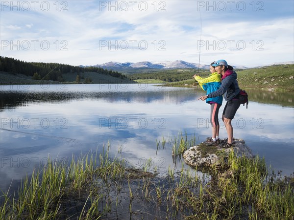 Mother and daughter fishing in river