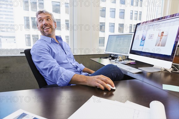 Caucasian businessman working at computer in office