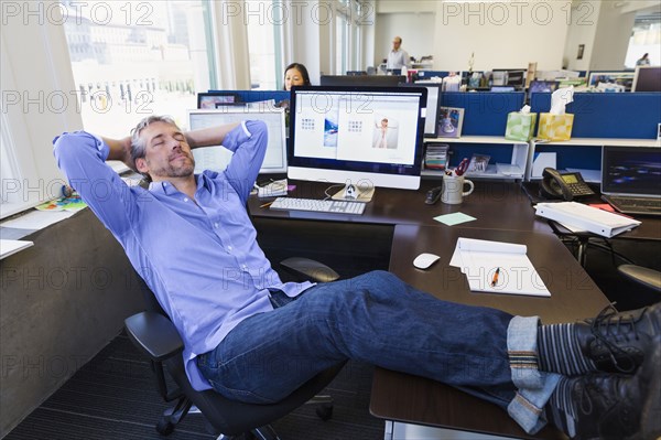 Businessman relaxing at desk in office