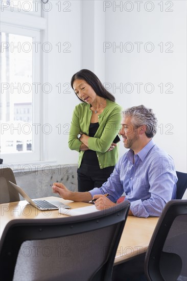 Business people working on laptop in conference room