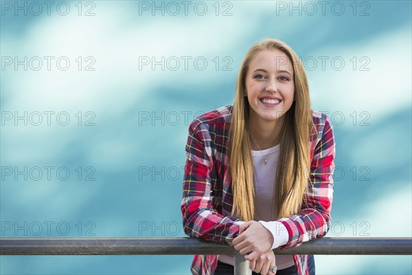 Smiling Caucasian woman leaning on banister