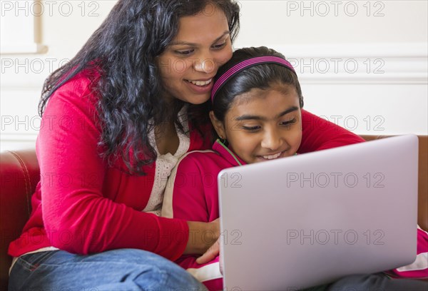 Indian mother and daughter using laptop