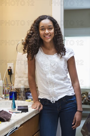 Mixed race teenage girl smiling in bathroom