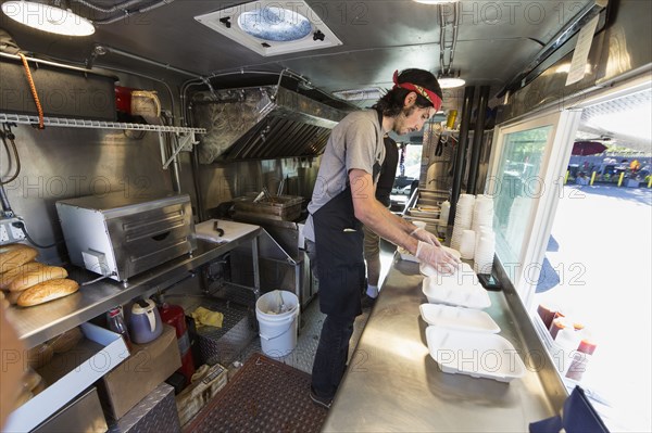 Caucasian chef working in food truck kitchen