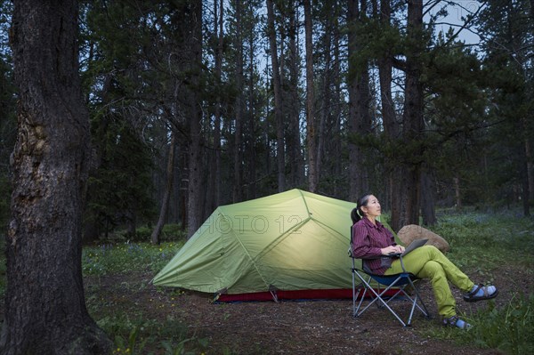 Japanese woman using laptop at campsite