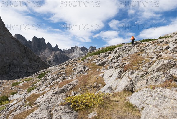 Caucasian hiker walking on rocky hillside