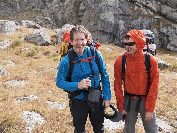 Caucasian hikers smiling on hillside