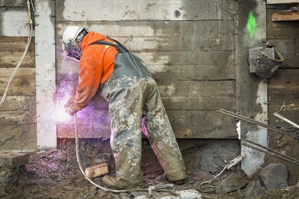 Caucasian worker welding at construction site