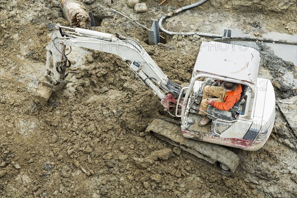 Caucasian worker operating digger at construction site