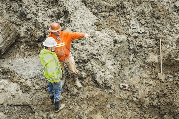 Caucasian workers talking at construction site