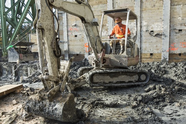 Caucasian worker using digger at construction site