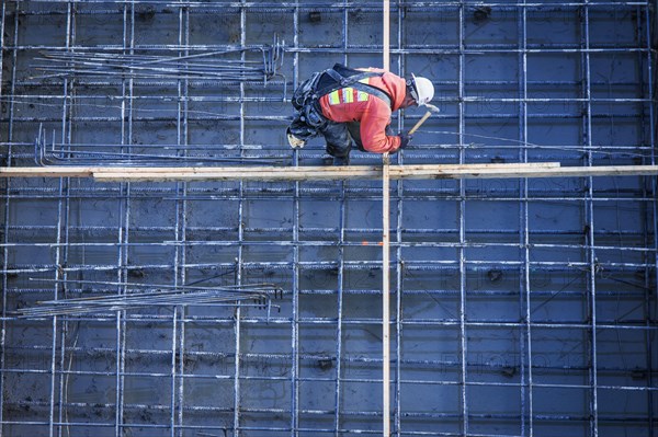 Caucasian worker nailing boards at construction site