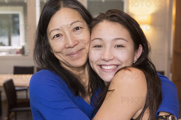 Mother and daughter hugging indoors