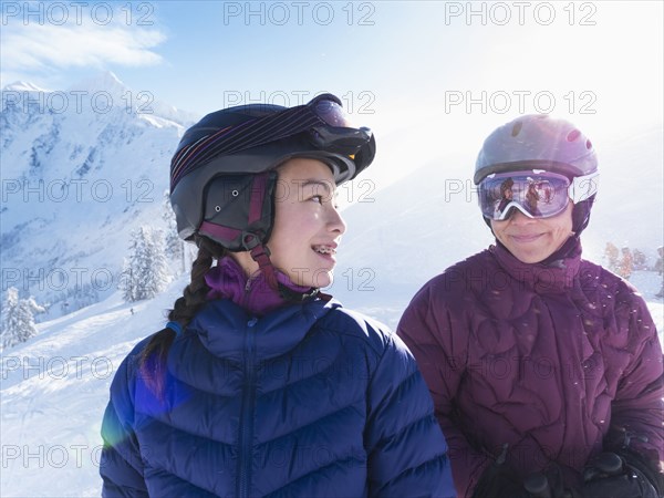 Mother and daughter wearing ski gear on snowy mountain