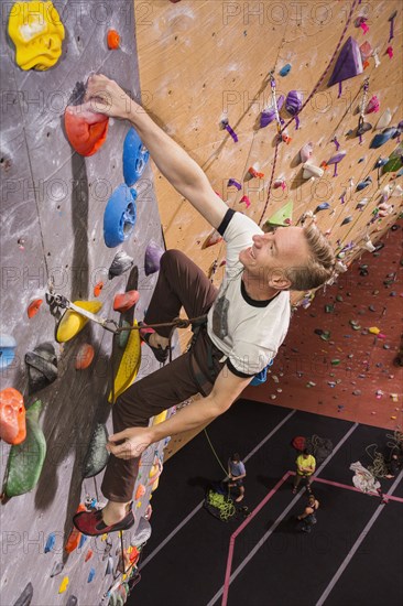 Caucasian man climbing rock wall