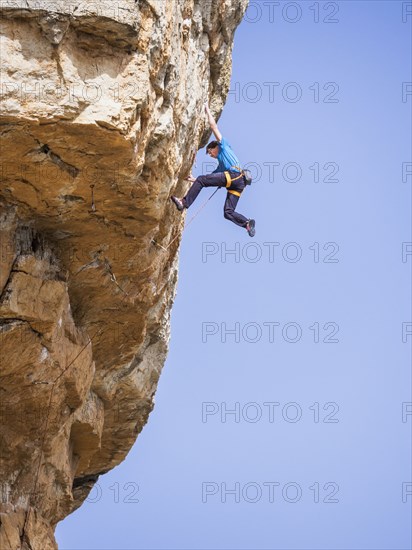 Caucasian man climbing rock