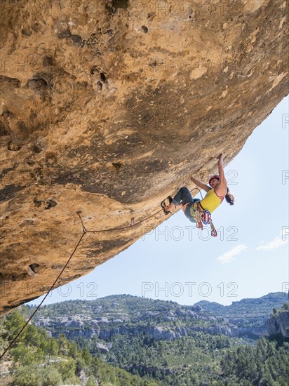 Mixed Race girl climbing rock