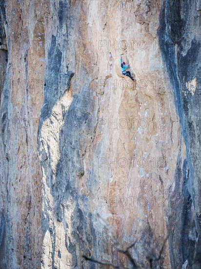 Mixed Race girl climbing rock