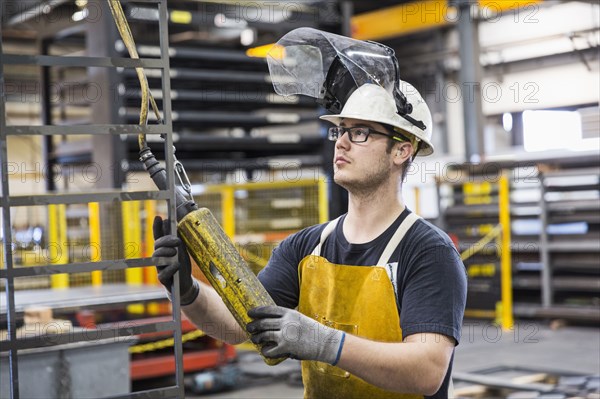 Caucasian worker holding controller in factory