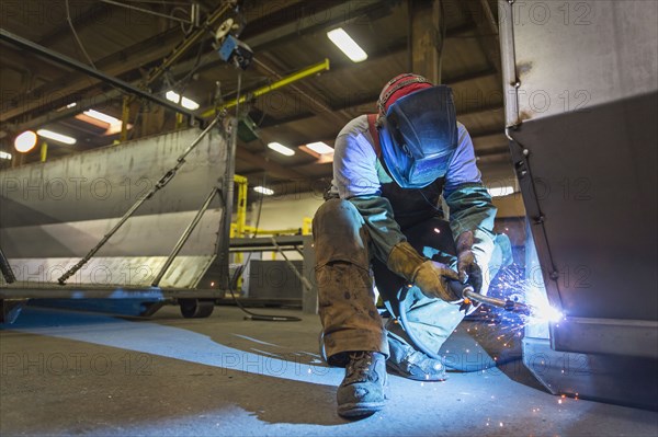 Caucasian man welding metal in factory