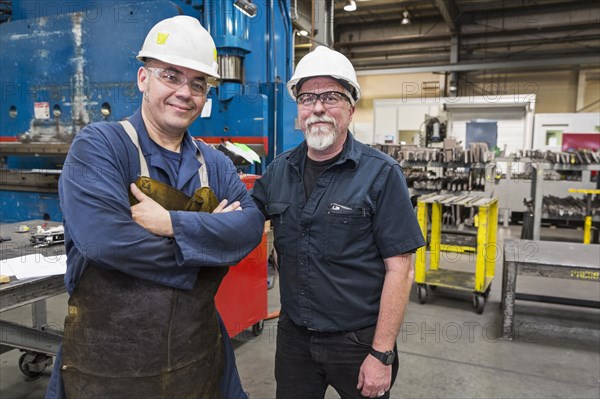 Smiling workers posing in factory