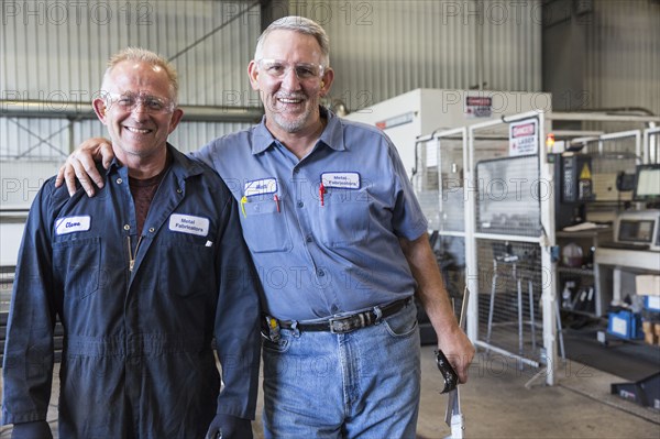 Smiling Caucasian workers posing in factory