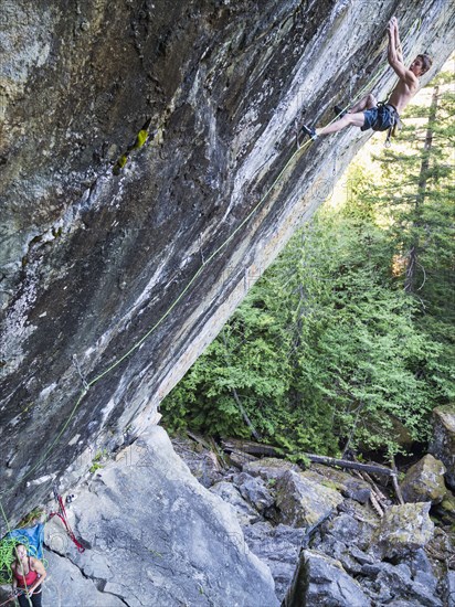 Girl watching boy climbing rock