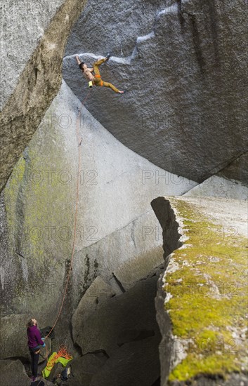 Girl watching boy rock climbing