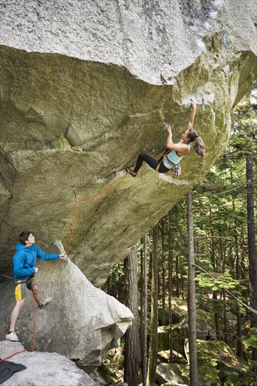 Boy watching girl rock climbing