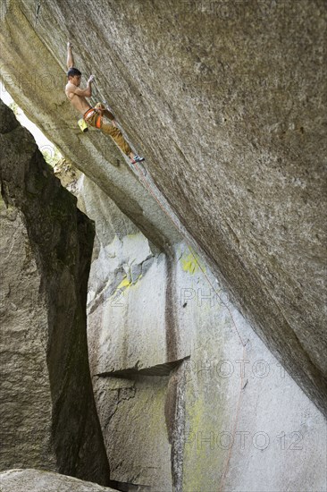 Mixed race boy climbing rock