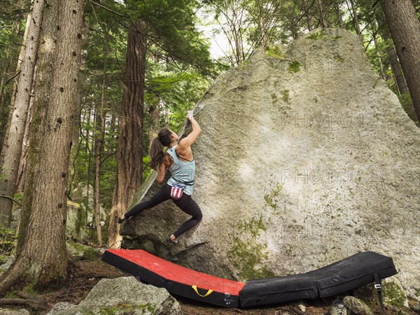 Mixed race girl climbing rock