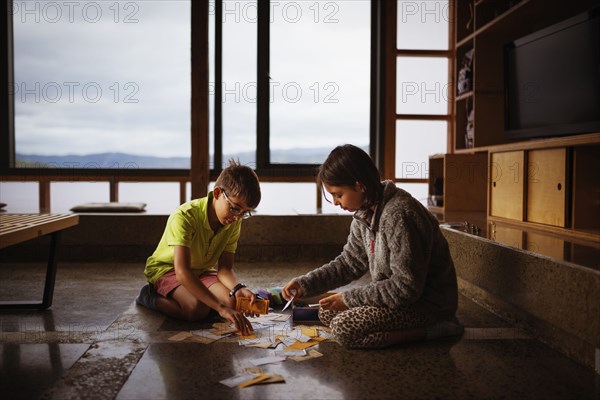 Mixed race children playing together on living room floor