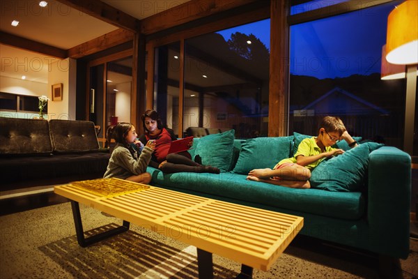 Mother and children relaxing together in modern living room