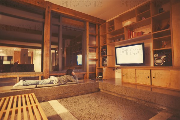 Mixed race girl watching television in modern living room