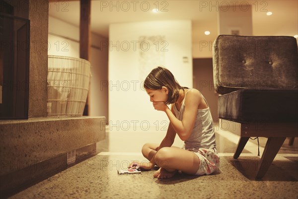 Mixed race girl using cell phone in living room