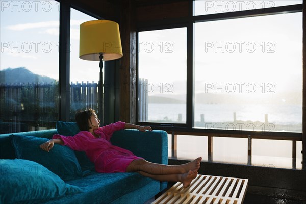 Mixed race girl looking out living room window