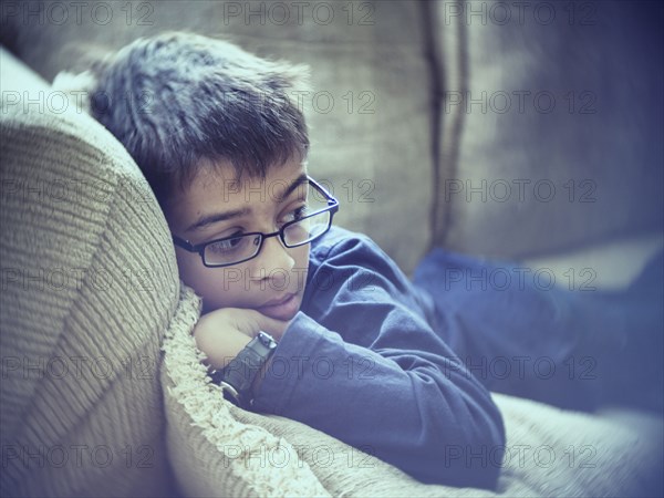 Mixed race boy laying on sofa