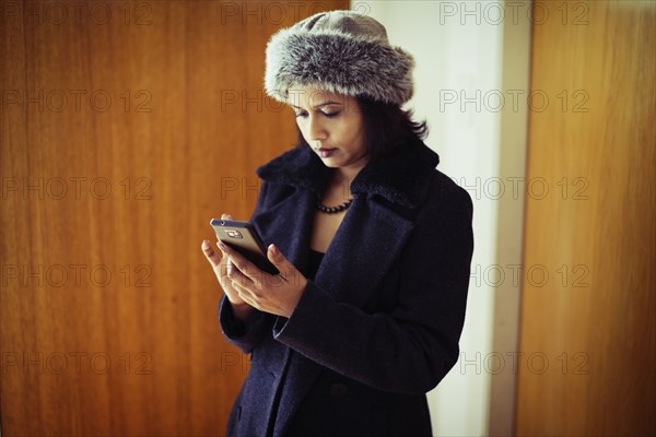 Mixed race woman using cell phone