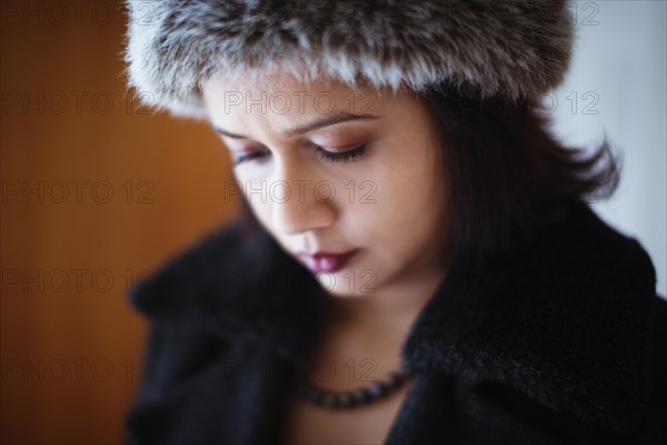 Mixed race woman wearing furry hat and coat